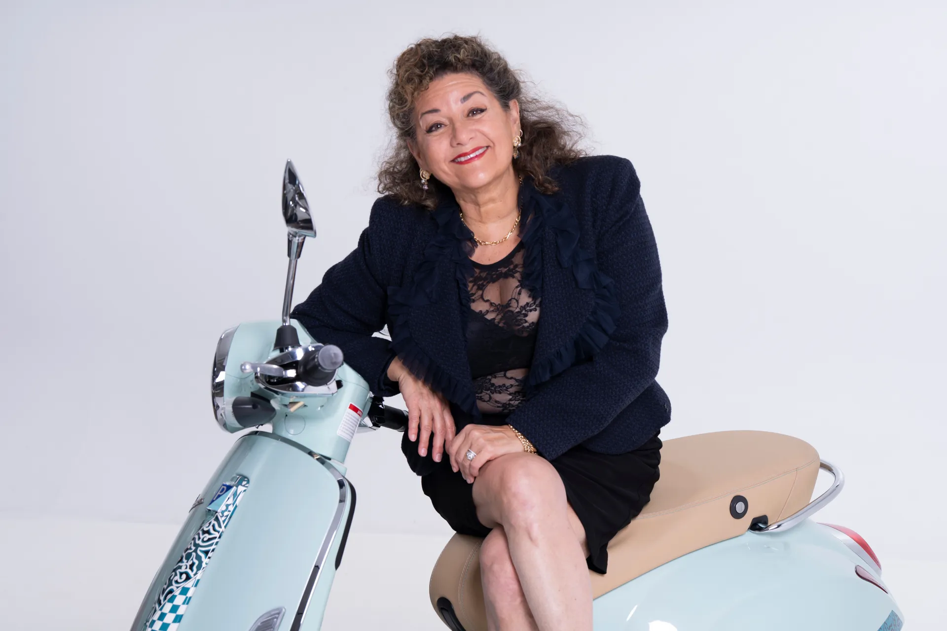Sharon Azrieli assise sur un scooter Vespa vert menthe, portrait en studio